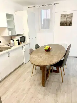 a kitchen with a wooden table and chairs in a kitchen at Cœur de Cannes in Cannes