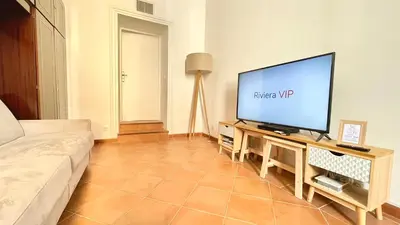 a living room with a couch and a tv at Spacious and calm studio close to the beach in Cannes