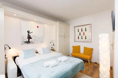 a white bedroom with a bed and a chair at Dolce Vita YourHostHelper in Cannes