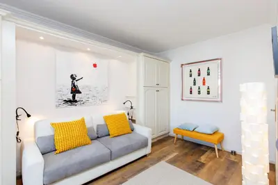 a living room with a white couch and yellow pillows at Dolce Vita YourHostHelper in Cannes