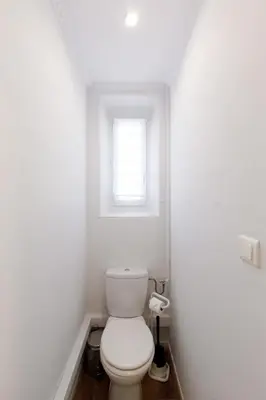 a white bathroom with a toilet and a window at Dolce Vita YourHostHelper in Cannes