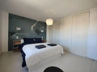 a bedroom with a large bed and a chandelier at Cannes Vue mer T2 61m²+ parking in Cannes