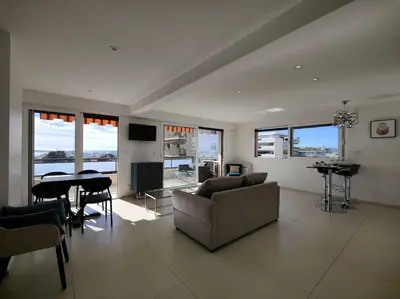 a living room with a couch and a table at Cannes Vue mer T2 61m²+ parking in Cannes