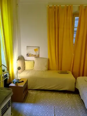 a bedroom with a bed with yellow curtains and a table at Beach House Cannes - Plages du Midi- 3 Ch - 3 Sdd - 2 wc - Fibre - Pkgs in Cannes