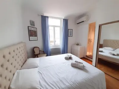 a bedroom with a large white bed and a mirror at Gloria in Cannes