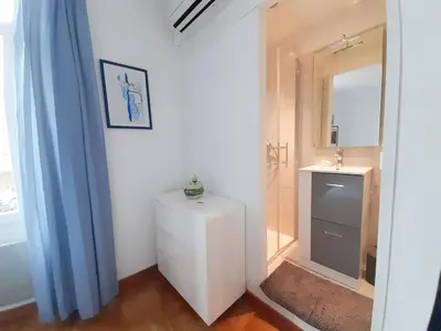 a bathroom with a white cabinet and a mirror at Gloria in Cannes