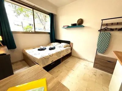 a small room with a bed and a window at Cannes city center cozy studio 100 m from beach AC Wifi all within walking distance in Cannes