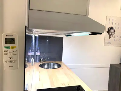 a kitchen counter with a sink and a refrigerator at Cannes city center cozy studio 100 m from beach AC Wifi all within walking distance in Cannes