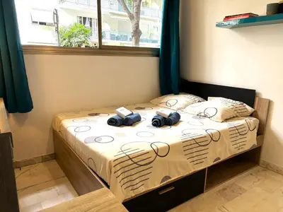 a bedroom with a bed with two cameras on it at Cannes city center cozy studio 100 m from beach AC Wifi all within walking distance in Cannes