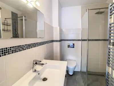 a white bathroom with a sink and a toilet at Appartements centre ville Cannes in Cannes