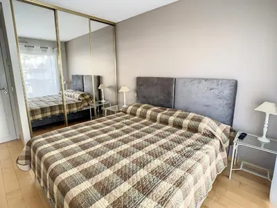 a bedroom with a large bed with a plaid blanket at Appartements centre ville Cannes in Cannes