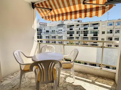 a table and chairs on a balcony with a view of a building at Appartements centre ville Cannes in Cannes