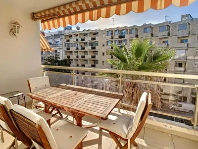 a table and chairs on a balcony with a view of a city at Appartements centre ville Cannes in Cannes