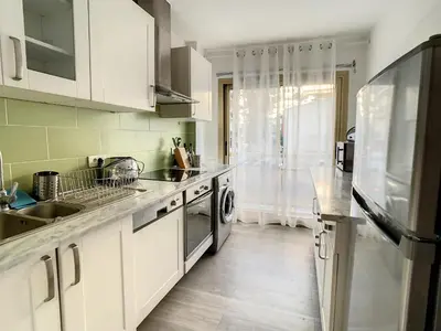 a kitchen with white cabinets and a sink and a dishwasher at Appartements centre ville Cannes in Cannes