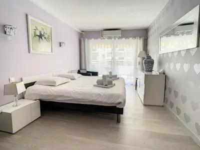 a bedroom with a large white bed and a window at Appartements centre ville Cannes in Cannes