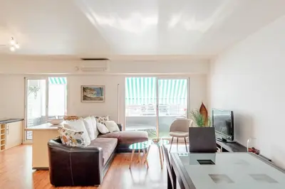 a living room with a couch and a table at Bright 2 Bed Apt in Cannes, 10 min to Palais in Cannes