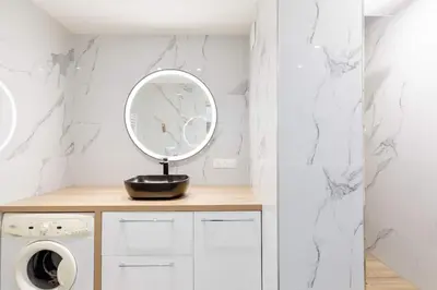 a bathroom with a mirror and a washing machine at Bright 2 Bed Apt in Cannes, 10 min to Palais in Cannes
