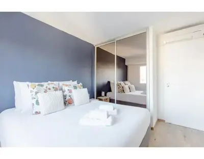 a bedroom with a large white bed with a mirror at Bright 2 Bed Apt in Cannes, 10 min to Palais in Cannes