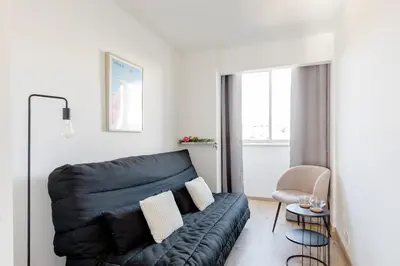 a living room with a couch and a chair at Bright 2 Bed Apt in Cannes, 10 min to Palais in Cannes