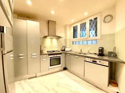 a white kitchen with a sink and a stove at La Rotonde By SCLS Locations in Cannes