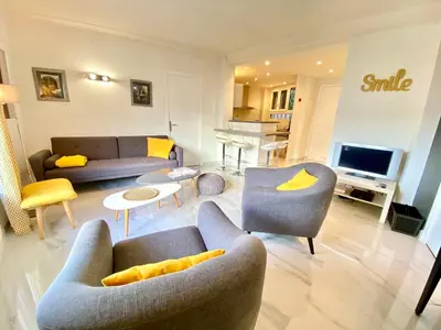 a living room with couches and chairs and a television at La Rotonde By SCLS Locations in Cannes
