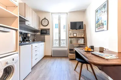 a kitchen with a table and a clock on the wall at 
