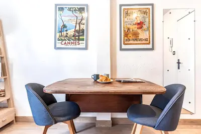 a dining room table with two chairs and two posters at 