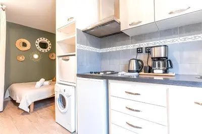 a kitchen with white cabinets and a washer and dryer at 