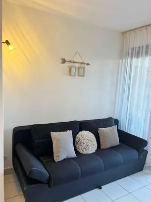 a blue couch with pillows in a living room at Front de mer, 8min du Palais des Festivals in Cannes