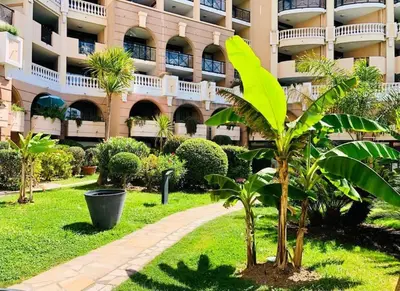 a palm tree in front of a building at Front de mer, 8min du Palais des Festivals in Cannes