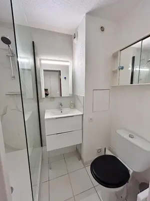 a white bathroom with a sink and a toilet at Front de mer, 8min du Palais des Festivals in Cannes