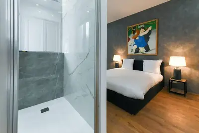 a bedroom with a bed and a glass shower at 3 DAUMAS - Superbe appartement 2 chambres hyper centre Cannes in Cannes