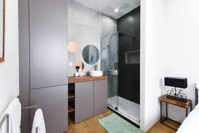 a bathroom with a shower and a vanity with a mirror at 3 DAUMAS - Superbe appartement 2 chambres hyper centre Cannes in Cannes