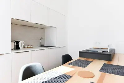 a kitchen with a table and chairs and a counter at 3 DAUMAS - Superbe appartement 2 chambres hyper centre Cannes in Cannes