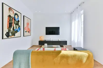 a living room with a bed and a tv at 3 DAUMAS - Superbe appartement 2 chambres hyper centre Cannes in Cannes