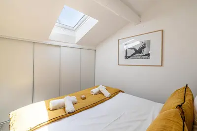 a bedroom with a bed with a skylight at MEY T3 - Magnifique LOFT 3 pièces à 50m du vieux port et des plages in Cannes