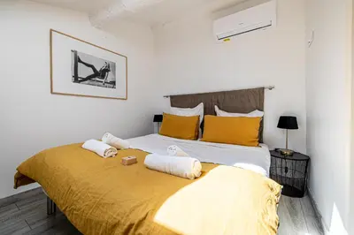 a bedroom with a large bed with yellow pillows at MEY T3 - Magnifique LOFT 3 pièces à 50m du vieux port et des plages in Cannes