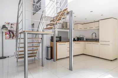 a kitchen with a spiral staircase in a house at MEY T3 - Magnifique LOFT 3 pièces à 50m du vieux port et des plages in Cannes