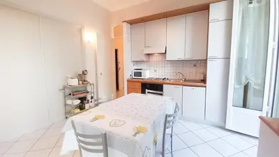 a white kitchen with a table and a sink at Mimosa 1 in Cannes
