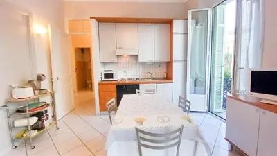 a kitchen with a table and a kitchen with white cabinets at Mimosa 1 in Cannes