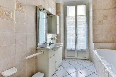 a bathroom with a sink and a tub and a mirror at Mimosa 1 in Cannes
