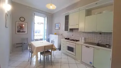 a kitchen with white cabinets and a table and a window at Mimosa 2 in Cannes