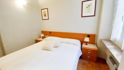 a bedroom with a white bed and two night stands at Mimosa 2 in Cannes