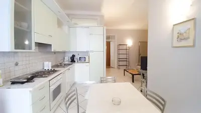 a kitchen with white cabinets and a table in it at Mimosa 2 in Cannes