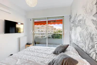 a bedroom with a bed and a large window at Appartement, 2 pièces, à deux pas de la Croisette in Cannes