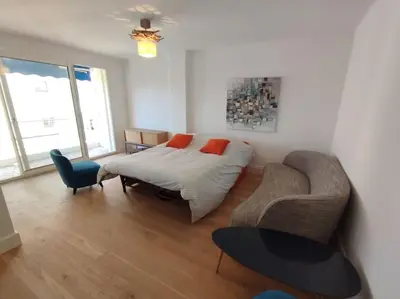 a bedroom with a bed and a couch and a chair at Cannes Pointe Croisette T2 plage 2min à pieds 46m2 in Cannes