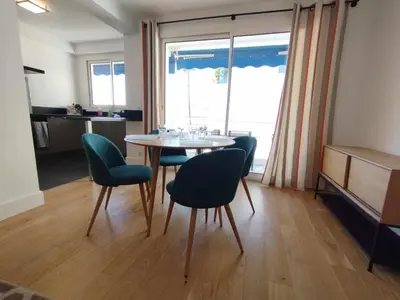 a dining room with a table and chairs and a window at Cannes Pointe Croisette T2 plage 2min à pieds 46m2 in Cannes