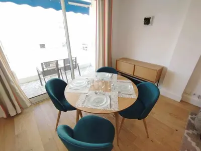 a dining room with a table and blue chairs at Cannes Pointe Croisette T2 plage 2min à pieds 46m2 in Cannes