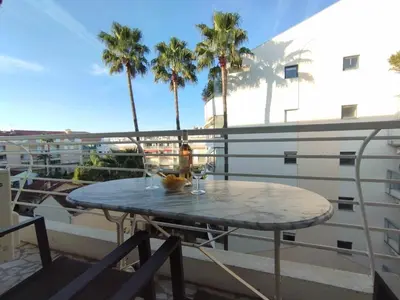 a table on a balcony with palm trees at Cannes Pointe Croisette T2 plage 2min à pieds 46m2 in Cannes