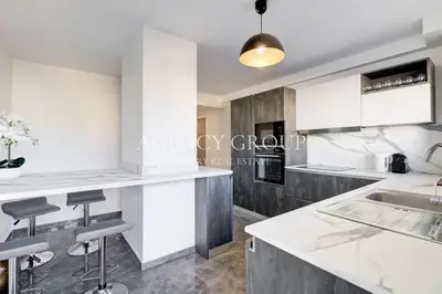 a kitchen with white cabinets and bar stools at Appartement 3P - Vue Mer - Proche de la Croisette in Cannes